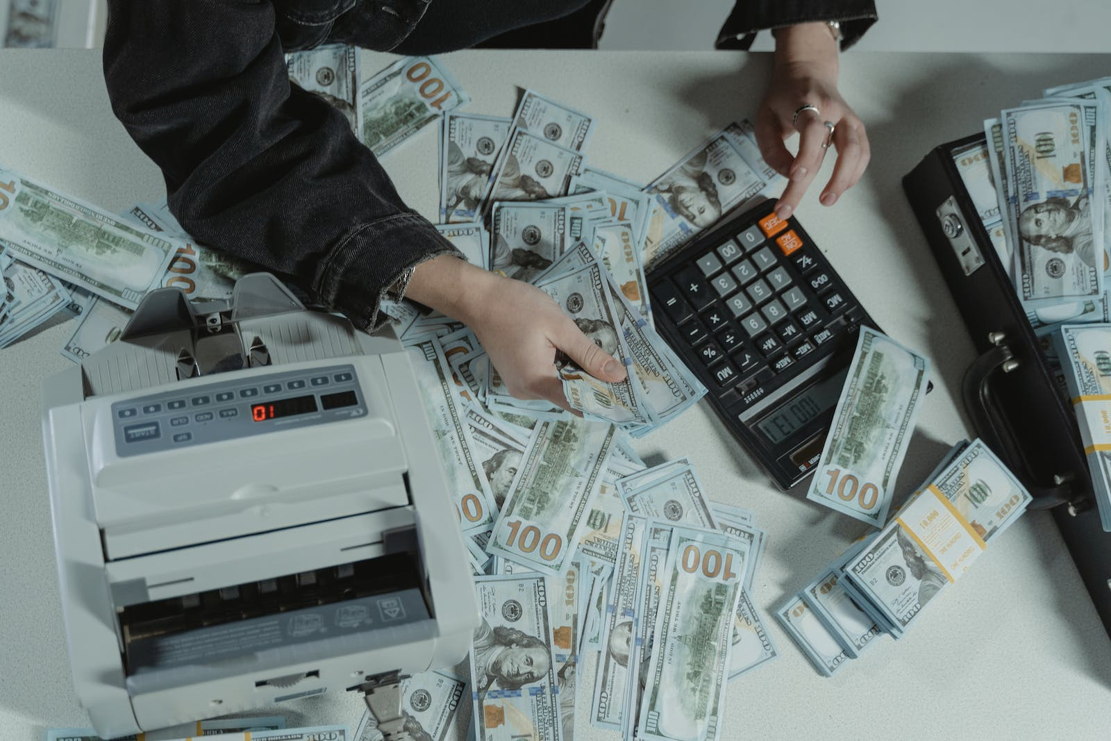 A Person Counting A Stack Of Money, Representing Money Laundering